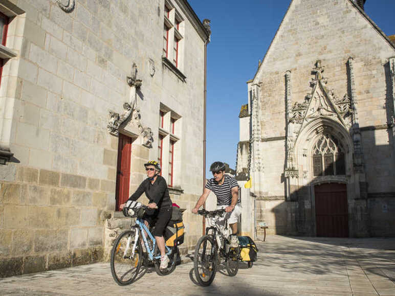 2 personnes à vélo dans les rues de Sainte Catherine de Fierbois sur la Véloroute Saint-Jacques à vélo