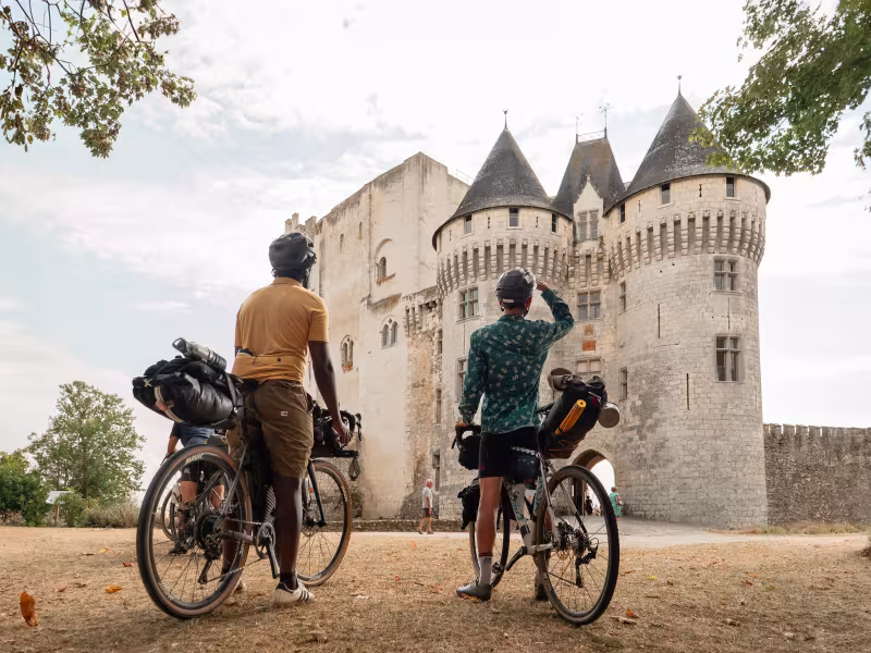 Deux cyclistes se tenant face au château des Comtes du Perche à Nogent-le-Rotrou