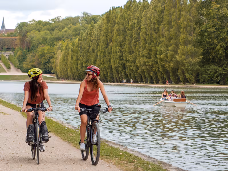 Deux cyclistes sur la Véloscénie longent le Grand Canal du domaine de Sceaux, étape emblématique entre Paris et Mont-Saint-Michel.