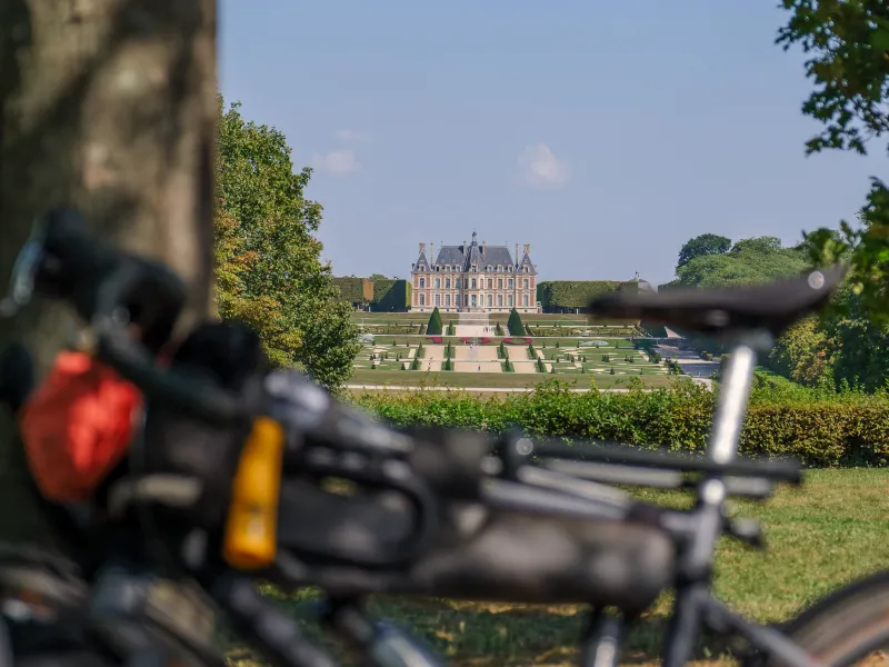 Vélos de voyage sur la coulée verte du sud parisien avec vue sur le château et les jardins du domaine de Sceaux, étape de la Véloscénie en Île-de-France.