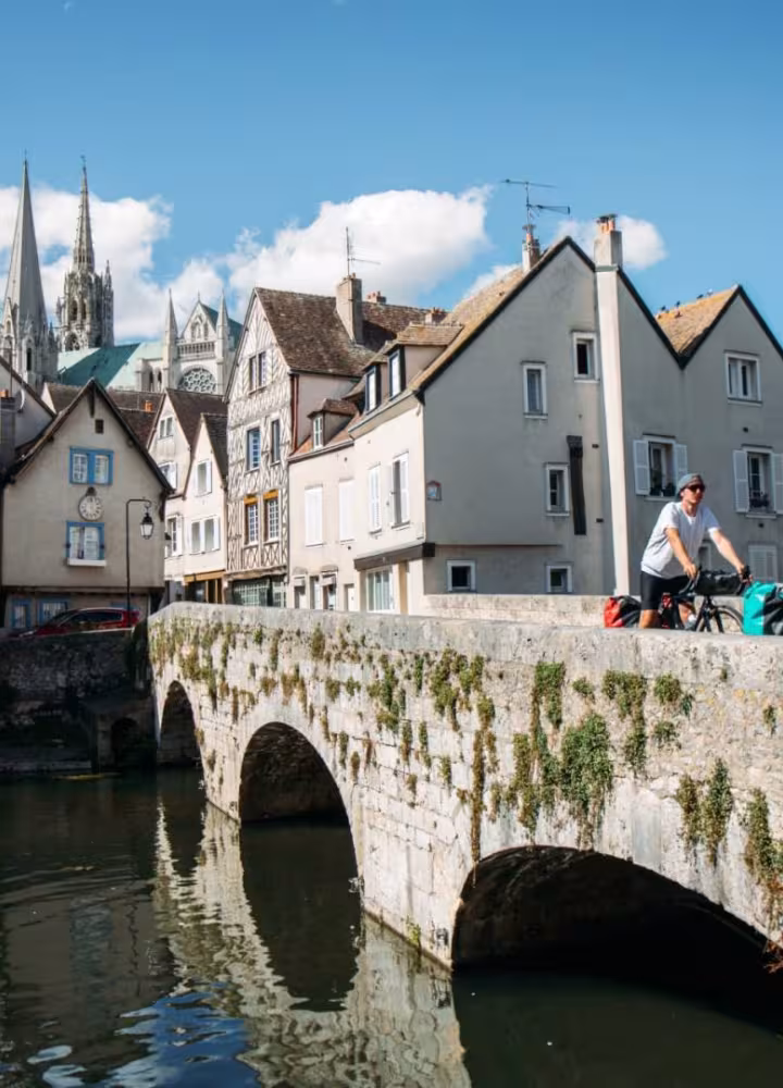 Cyclistes traversant le pont Bouju à Chartres avec vue sur la cathédrale depuis la Basse Ville