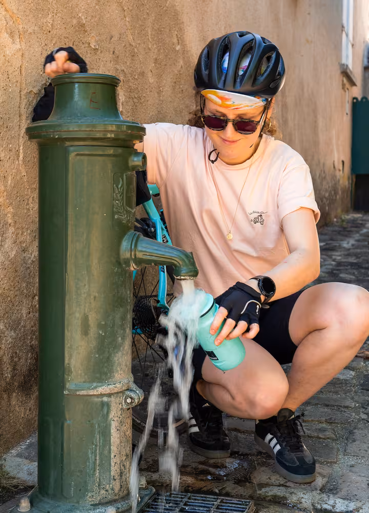 Cycliste s'hydratant à un point d'eau public pendant une canicule à Rochefort-en-Yvelines sur la Véloscénie