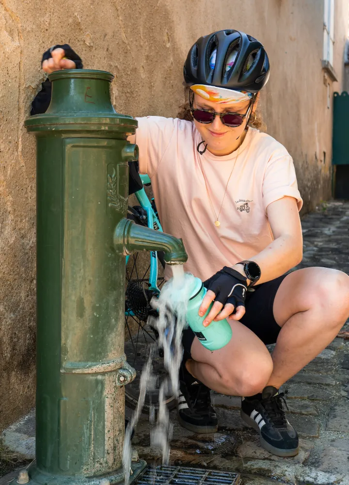 Cycliste s'hydratant à un point d'eau public pendant une canicule à Rochefort-en-Yvelines sur la Véloscénie