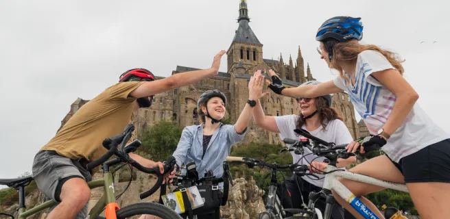 Voyageurs à vélo heureux d'être arrivés au Mont Saint-Michel