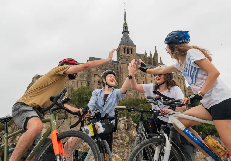 Voyageurs à vélo heureux d'être arrivés au Mont Saint-Michel