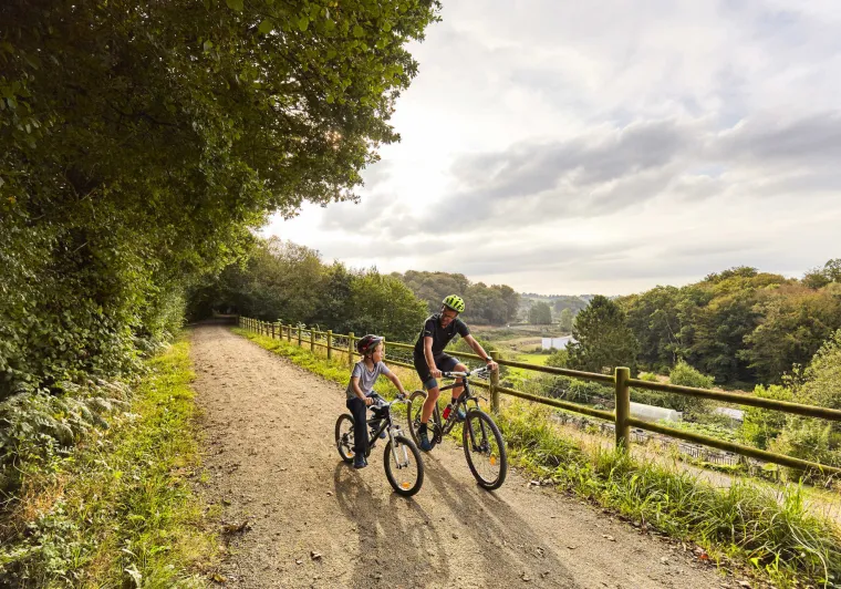 Père et son fils roulant sur la voie verte près de Mortain sur la véloroute La Véloscénie 