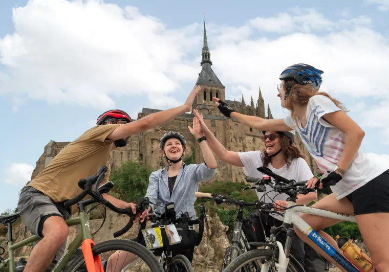 Cyclistes célébrant leur arrivée au pied du Mont Saint-Michel