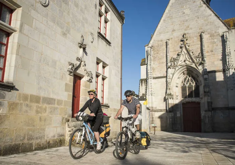 2 personnes à vélo dans les rues de Sainte Catherine de Fierbois sur la Véloroute Saint-Jacques à vélo