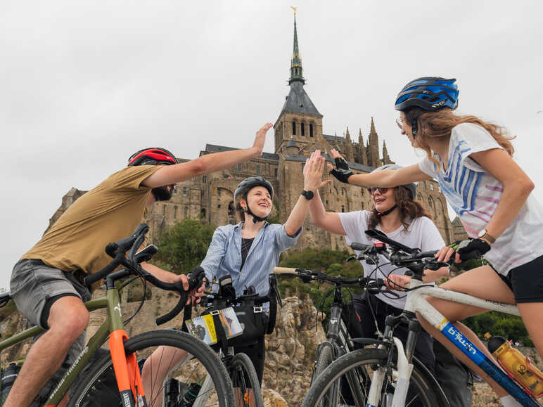 Voyageurs à vélo heureux d'être arrivés au Mont Saint-Michel
